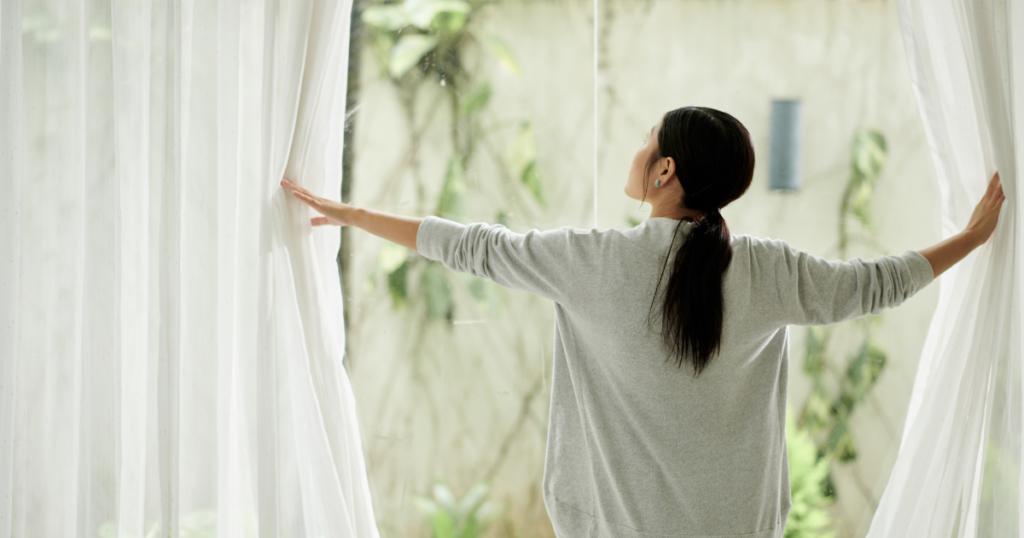窓を開ける女性